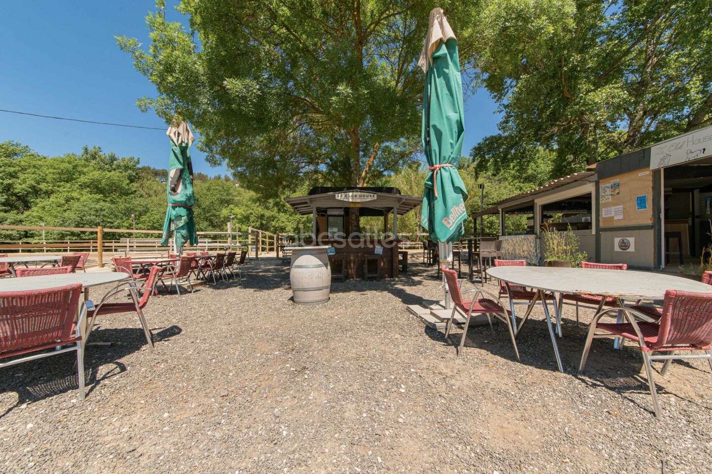 La terrasse en gravier sous les grands arbres, en journée